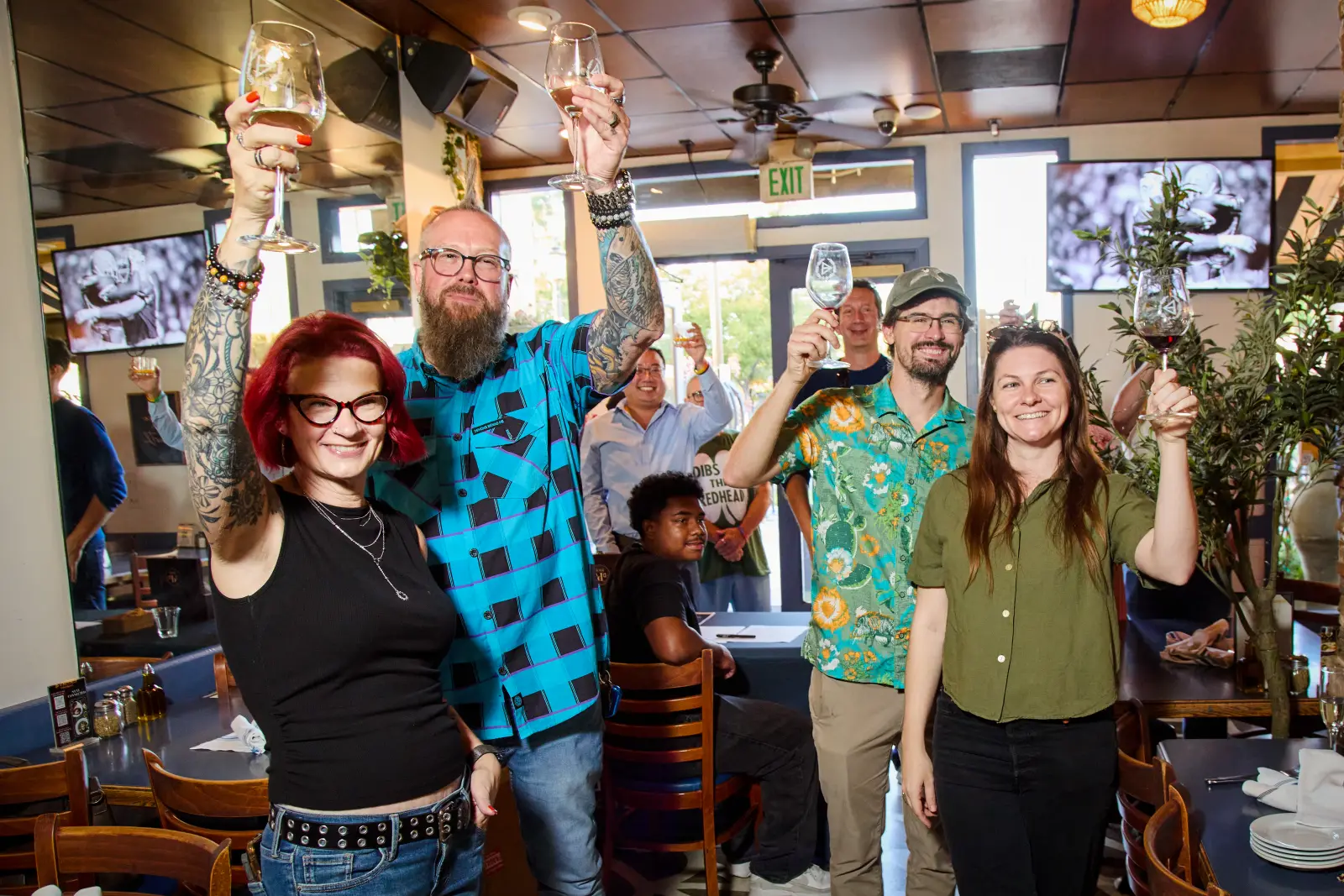 Guests raising their glasses together across the room at Demitri’s Taverna