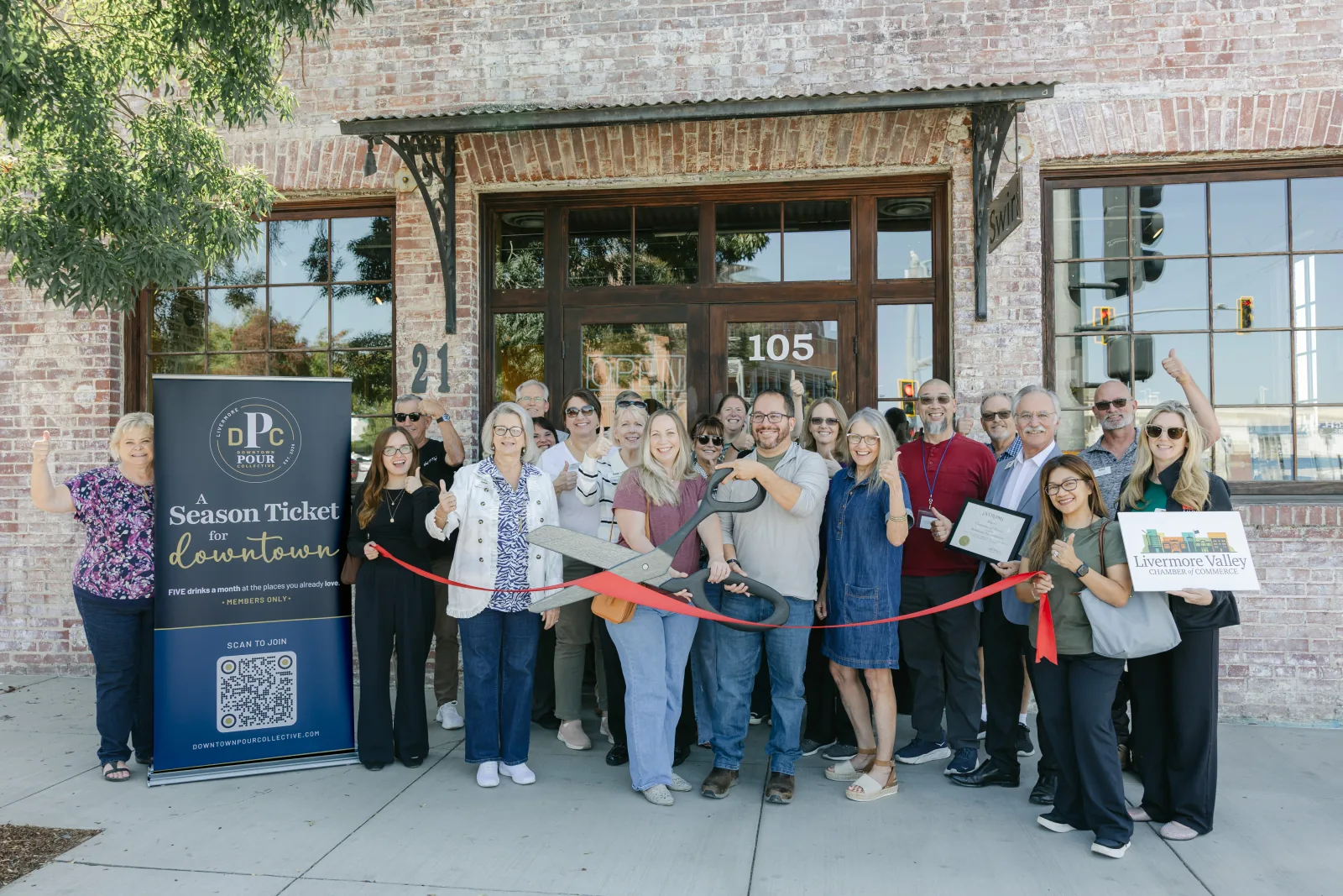 The DPC ribbon cutting outside Swirl on the Square with the Chamber group and DPC banner